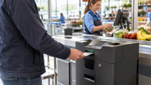 Klant betaalt contant bij een gesloten kassasysteem naast de kassa in een supermarkt